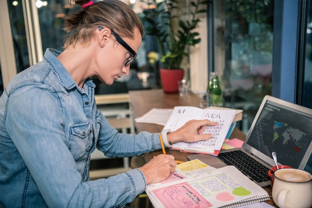 Foto schwer arbeitender student. intelligenter männlicher student, der hart lernt, während er sich auf eine prüfung vorbereitet