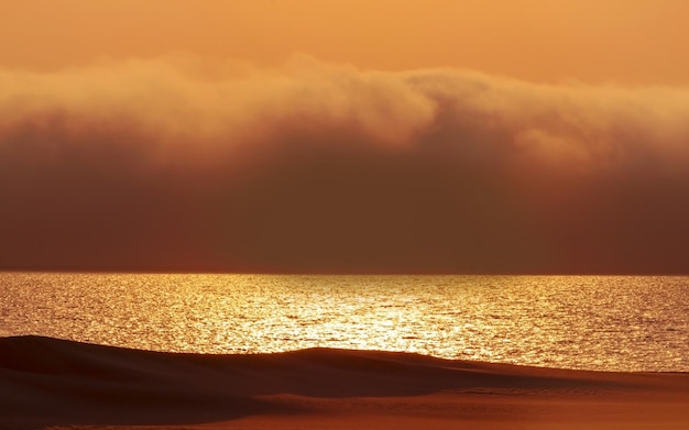 Schwere dramatische Wolken und heller Himmel über dem Atlantischen Ozean Schöner Sonnenuntergang in der afrikanischen Wüste