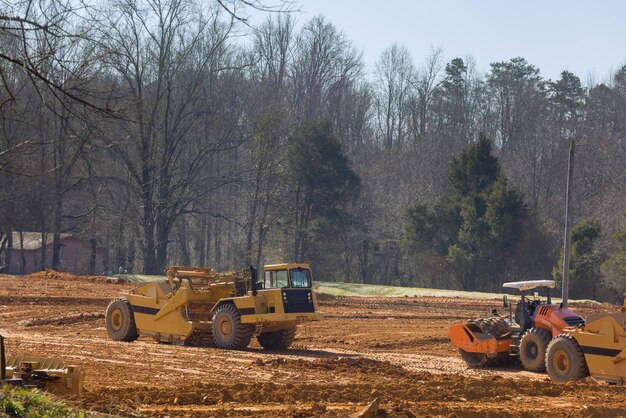 Schwere Traktormaschinen richten das Land für die Baustelle aus