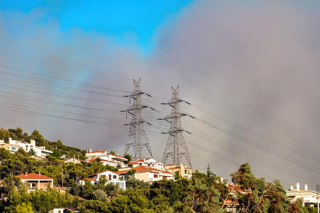 Schwerer dunkelgrauer Rauch Feuer im Wald von Athen Griechenland Bäume und bewohnbare Häuser Hintergrund