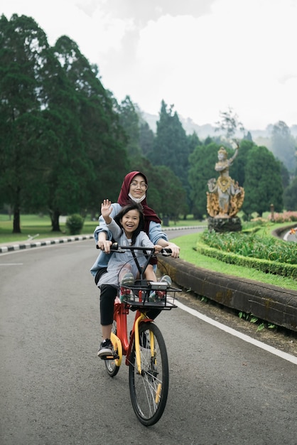 Schwester nimmt ihre Geschwister mit auf dem Fahrrad im Park