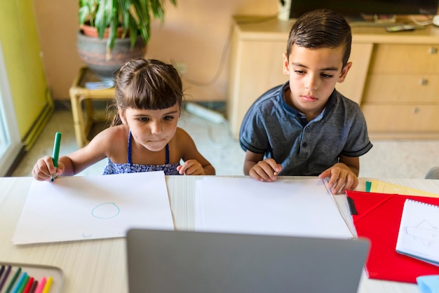 Schwester und Bruder nehmen zu Hause Online-Unterricht