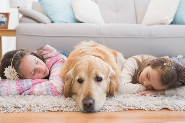 Schwestern, die auf Wolldecke mit golden retriever Nickerchen machen