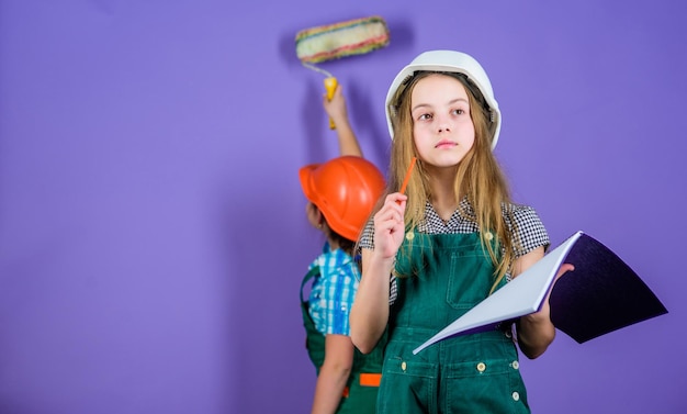 Schwestern freuen sich über die Renovierung ihres Hauses Heimwerkeraktivität Kindermädchen planen Renovierung Wände neu streichen Einzug in neue Wohnung Kinderschwestern führen die Renovierung ihres Zimmers durch Kontrollieren den Renovierungsprozess