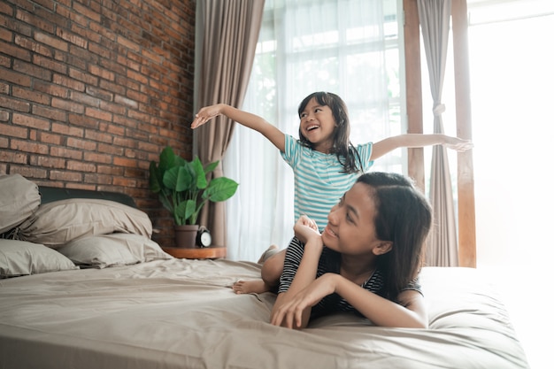 Schwestern spielen zusammen auf dem Bett