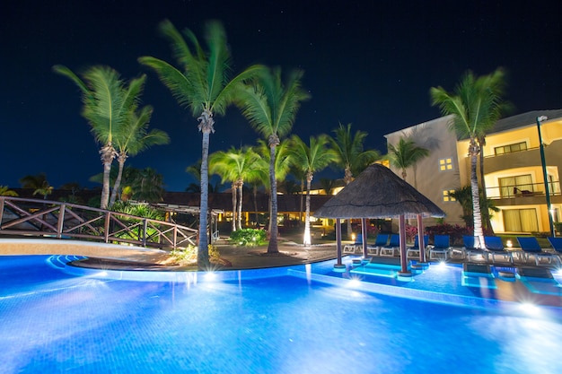 Schwimmbad bei Nachtbeleuchtung. tropisches Resort in der Nacht