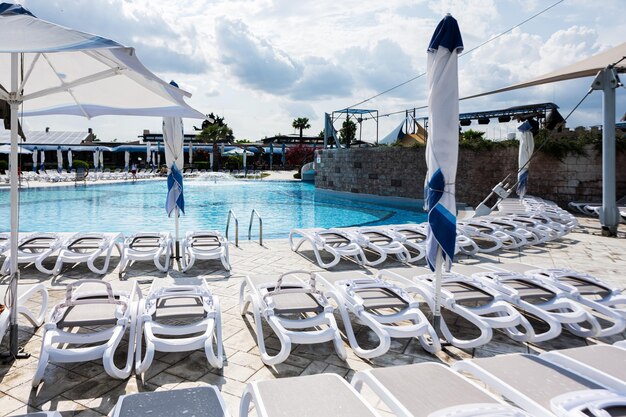 Schwimmbad mit Liegestühlen und Regenschirmen im Resort