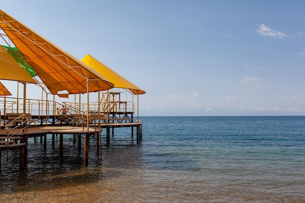 Schwimmbereich oder Pier am Meer Ein großer Pier mit Dach, Holzplanken und rostigen Treppen, die absteigen