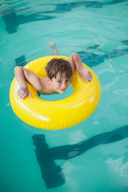 Schwimmen des kleinen Jungen mit Gummiring