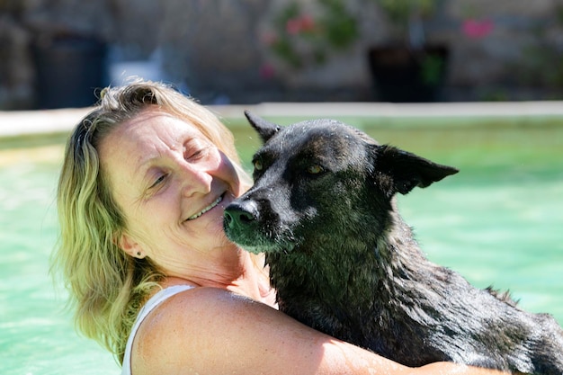 Schwimmender holländischer Schäferhund und Frau