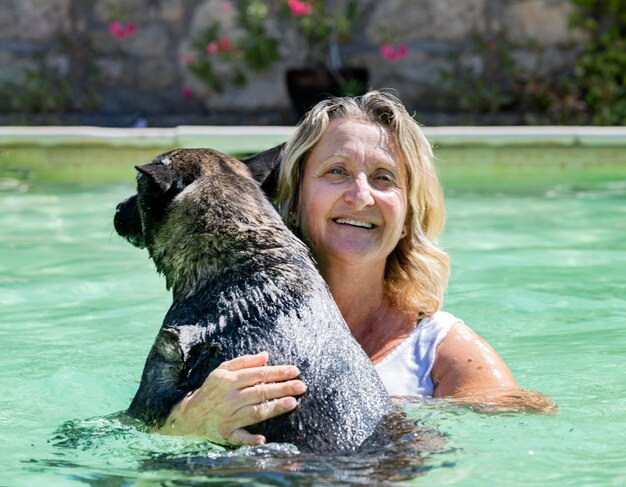 Schwimmender holländischer Schäferhund und Frau