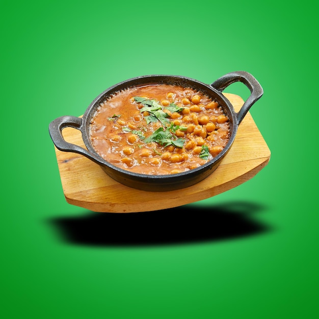 Schwimmendes Chana Masala in kleiner Pfanne auf Grün