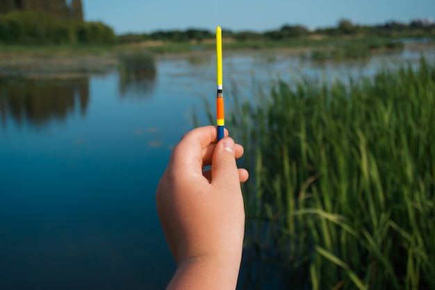 Schwimmer zum Angeln auf dem Hintergrund des Sees