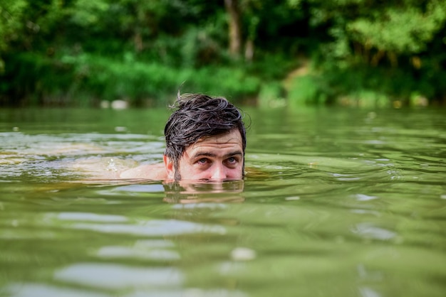 Schwimmsport Frische der wilden Natur Sommerurlaub Entspannung und Ruhe Schwimmfähigkeiten Erfrischendes Gefühl Der Mensch schwimmt gerne im Fluss oder See Tiefes gefährliches Wasser Untertauchen in Wasser