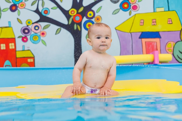 Schwimmunterricht für Kinder Ein kleiner Junge lernt im Babybecken schwimmen. Entwicklung der Kinder Erster Schwimmunterricht für Kinder
