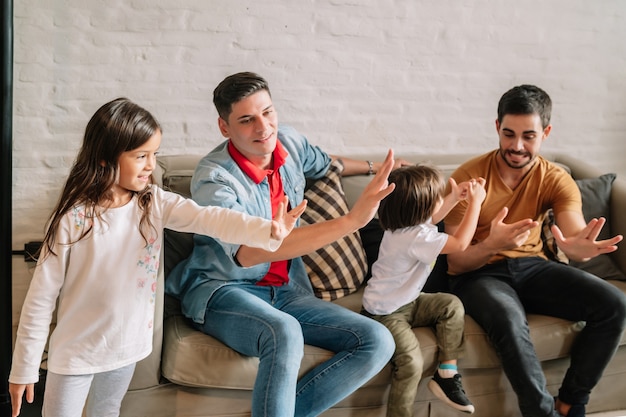 Schwules Paar hat Spaß beim Spielen mit ihren Kindern zu Hause. Familienkonzept.