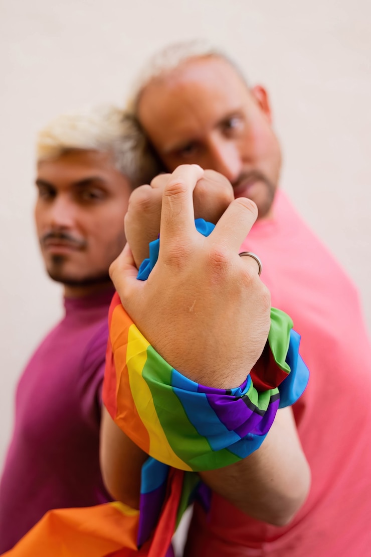 Foto schwules paar mit lgbt-flagge, die händchen hält