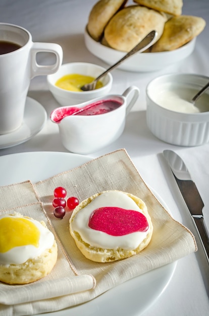 Scones com chantilly, coalhada de limão e geléia de cranberry