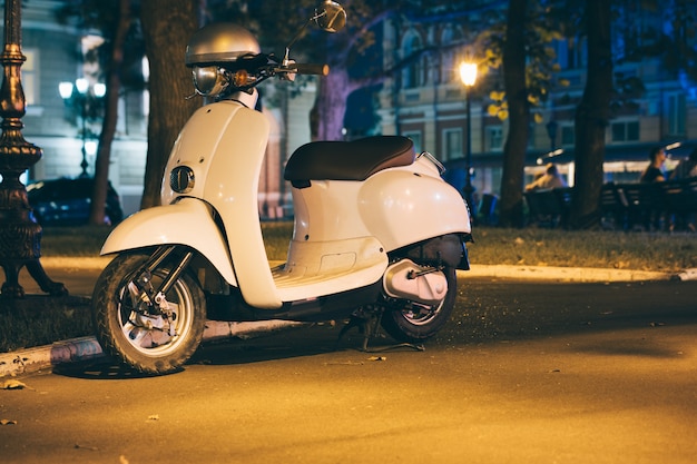 Scooter blanco en una ciudad de noche