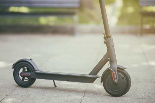 Scooter eléctrico negro en la carretera en el parque Transporte urbano eléctrico