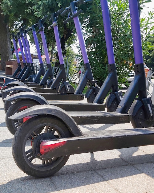 Scooters eléctricos esperando en la acera listos para ser alquilados y conducidos