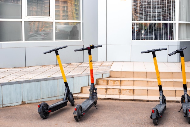 Scooters eléctricos en el estacionamiento fuera de la tienda Tecnología moderna móvil para moverse distancias cortas