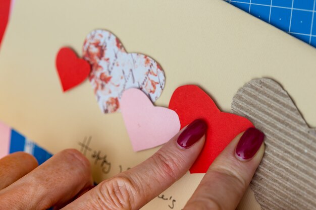 Scrapbook-Hintergrund. Mädchen macht eine Postkarte zum Valentinstag