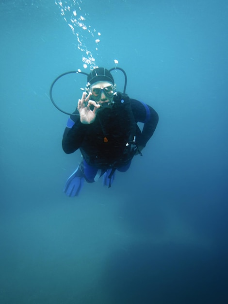 Scuba Diver bajo el agua que muestra la señal OK