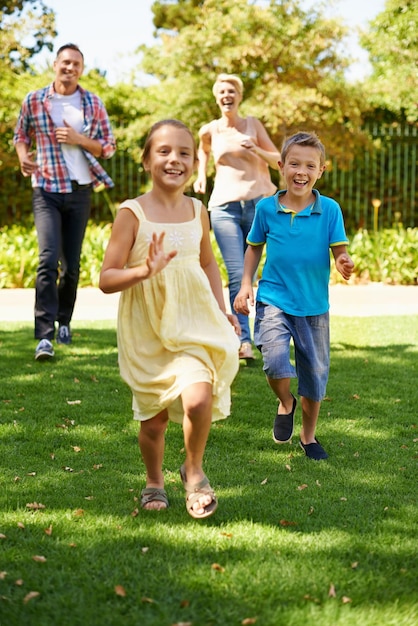 Se divertindo com sua família Uma foto de vista frontal de uma família feliz brincando no parque em um dia ensolarado