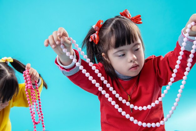 Se divertindo juntos. Menina atenta com transtorno mental lidando com contas decorativas e envolvida na celebração