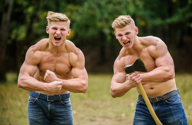 Sé fuerte Los hombres con torsos musculosos sexy lucen brutalmente Logrando el éxito en el deporte gemelos mesomorfos hombres musculosos con hacha hombre atlético usa hacha doble fuerza poder Concepto de masculinidad y brutalidad