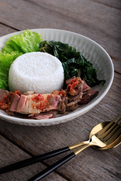 Se'i Sapi oder Beef Sei ist indonesisches traditionelles geräuchertes Rindfleisch, das mit gekochten Maniokblättern und Sambal Luat oder Sambal Matah serviert wird. Typisches Essen aus Nusa Tenggara, Indonesien