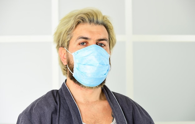 Se usar máscara, deve saber como usar e descartar adequadamente Proteger contra coronavírus Homem segura máscara facial O vírus é transmitido por gotículas e contato próximo Usando máscara Proteger contra vírus