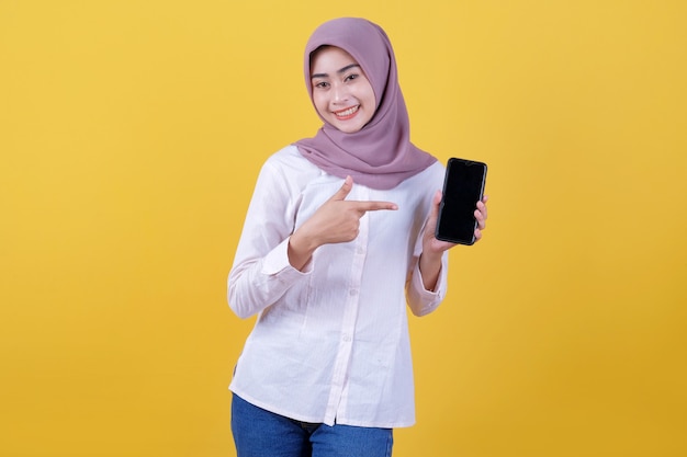 Sea inteligente, compre este dispositivo, retrato de una joven asiática riendo a carcajadas, con hijab apuntando al teléfono inteligente, mostrando la pantalla del dispositivo