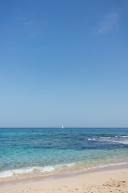 Sea Shore Sandstrand Landschaft mit blauem Himmelshintergrund an Sonne Sommertag Ocean Urlaub Konzept Digitale Entgiftung Isolation auf tropischen Insel Weißes Segelboot auf Welle Ruhiger, ruhiger Geisteszustand