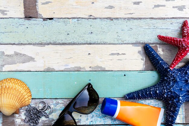 Searelated Konzepte Reisezubehör Sonnenschutz blau und rot Seestern Sonnenbrille Muscheln auf Holzboden platziert