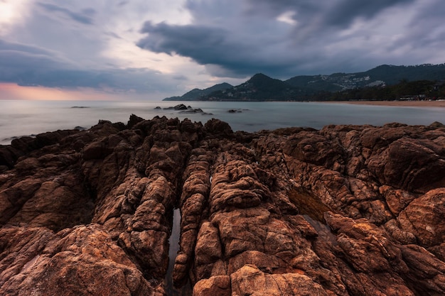 Seascape artístico com rochas de granito na costa do mar em frente ao céu colorido do nascer do sol Samui Tailândia