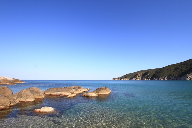 Seascape com rochas costeiras, águas claras e céu azul