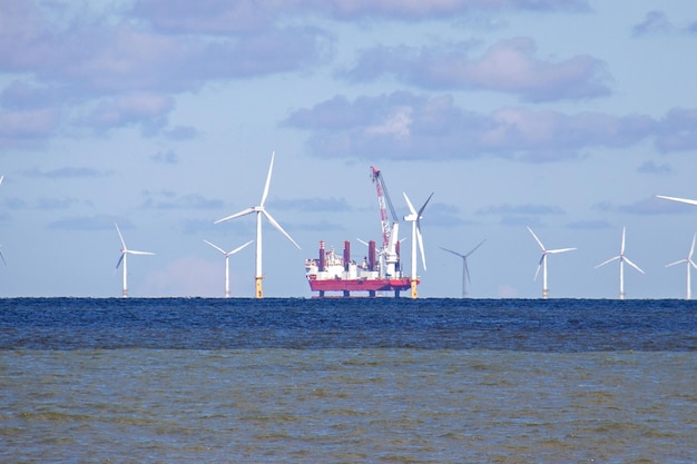 Seascape com um parque eólico e uma plataforma de gás no Se North Wales irlandês