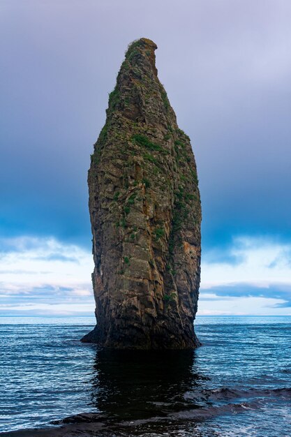 Seascape da costa oceânica de Kunashir com uma enorme rocha vertical na água