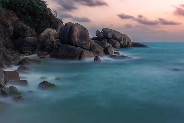 Seascape do nascer do sol com o céu colorido turva o mar e os pedregulhos gigantes do granito no litoral Samui Tailândia