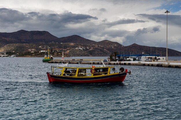 Seascape Ein Fischerboot segelt bei schlechtem Wetter vor dem Hintergrund der Stadt an einem kalten Wintertag auf dem Meer