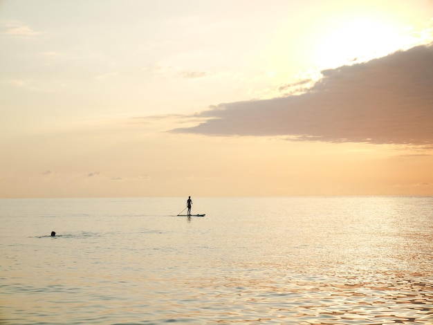 Seascape con una figura humana solitaria durante la puesta de sol