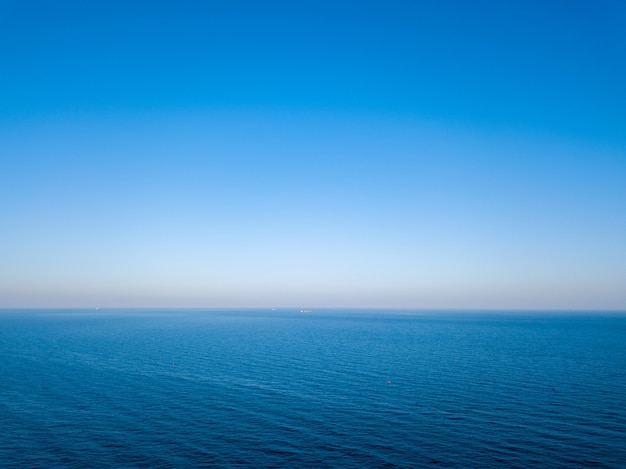 Seascape idílico com água azul e linha do horizonte manchada. vista aérea do zangão. fundo natural, lugar para texto.