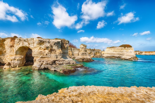 Seascape pitoresca com arco rochoso de falésias em Torre Sant Andrea