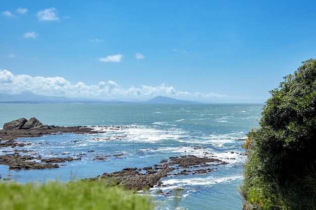 Seascape con verano costa rocosa del Océano Atlántico en el oeste de Francia con montañas en el horizonte