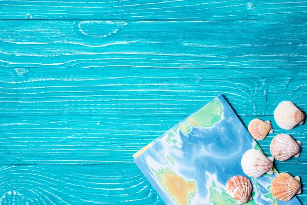 Seashells e mapa em fundo de madeira azul