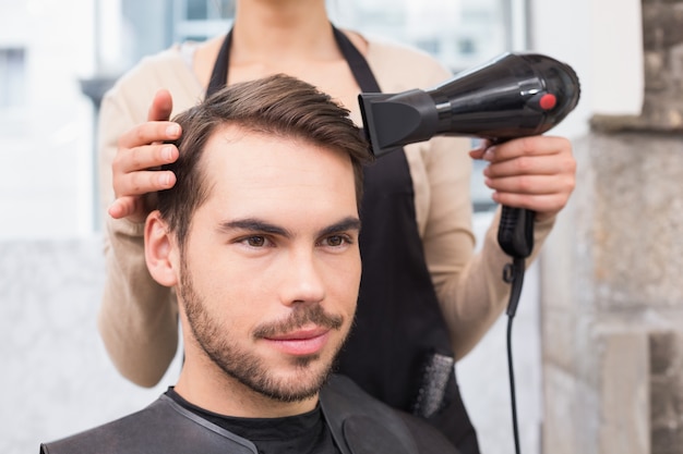 El secado del estilista sirve el pelo