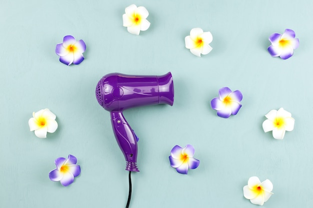 Secador de pelo morado con flores en madera azul