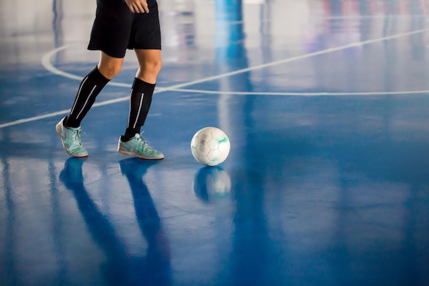 Foto seção baixa de homem jogando futebol na quadra